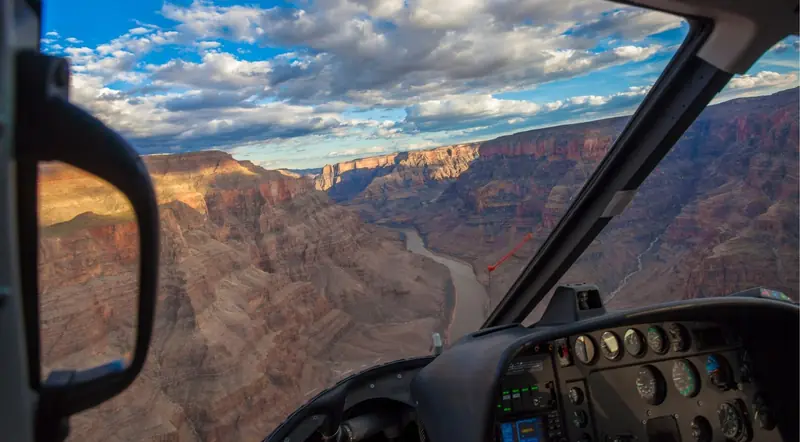 Grand Canyon helicopter flight above the Colorado River under a dramatic sky