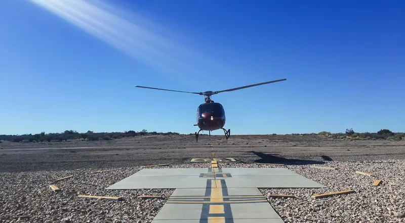 Grand Canyon tour helicopter lifting off from a desert helipad near Las Vegas