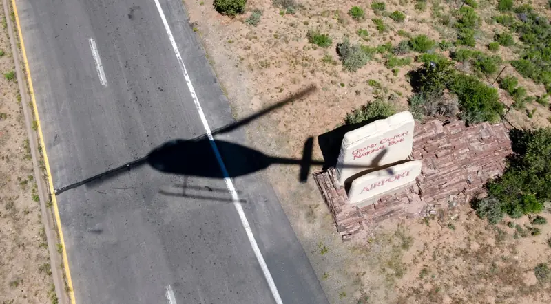 Helicopter rotor shadow over the Grand Canyon airport welcome sign